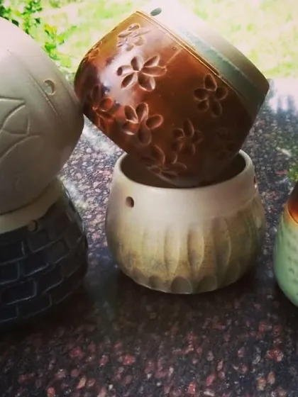 A collection of small planters and vases, each with its own distinct personality. I used different carving and texturing techniques, from floral imprints to geometric patterns, to make each pot a unique home for a small plant.