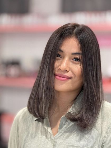 A beautiful ash hair color on a sleek, medium-length bob. The cut is simple and elegant, letting the cool-toned color be the star.