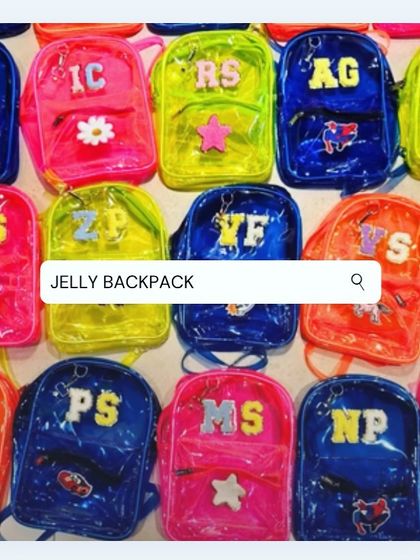 A large collection of our custom jelly backpacks, prepared as return favors. This image shows the variety of neon colors and initial personalizations that make each bag unique.