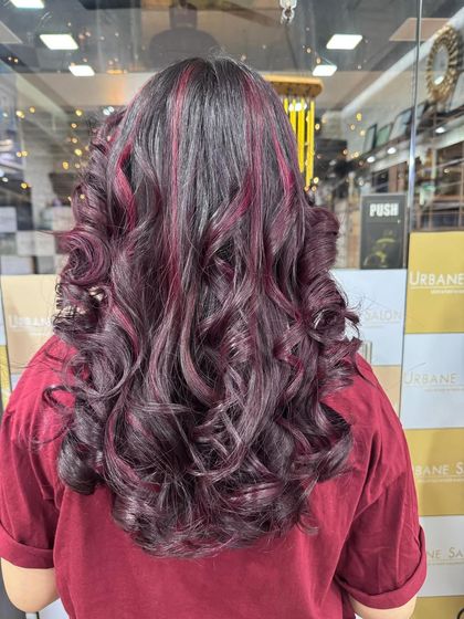 A beautiful combination of a rich global colour base with striking Plum Red highlights. The deep curls add texture and make the red tones pop.