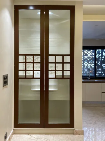 The temple when closed. The doors are made of wood and frosted glass, with small jali-work openings that offer a glimpse inside while maintaining a sense of privacy and sanctity.