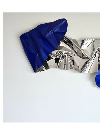 A detail shot showing the sharp, crisp folds of the blue section against the reflective silver.