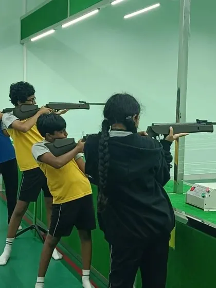 A group of students learns the proper standing posture for air rifle shooting. Our coaches break down every element of the sport into manageable steps, making it accessible and fun for all skill levels.