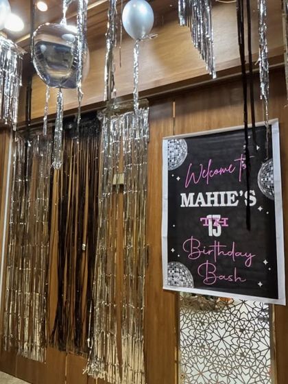 The party starts at the door. I created a welcoming entrance for 'Mahie's 13th Birthday Bash' with a custom sign and shimmering silver streamers to set the glamorous tone right away.