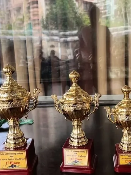 The trophies waiting for their champions. These are not just awards; they are symbols of dedication, sacrifice, and the relentless pursuit of excellence that I instill in all my swimmers.