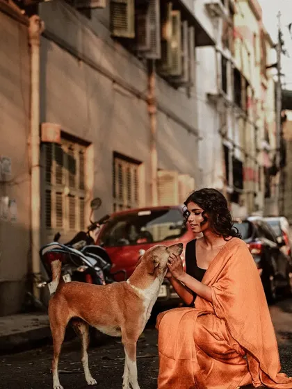 A heartwarming moment as a model interacts with a stray dog on the street. This candid shot adds a layer of authenticity and emotion to the fashion series.