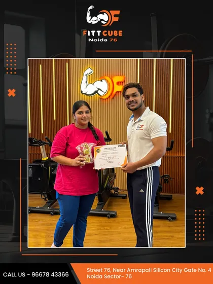 Progress recognized. A smiling client receives her certificate and a gift for her commitment to her personalized workout plan.