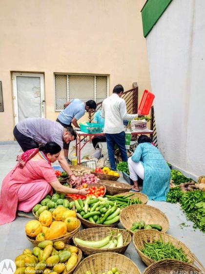 A group of customers gathered around a stall, deeply engaged in selecting their weekly produce.