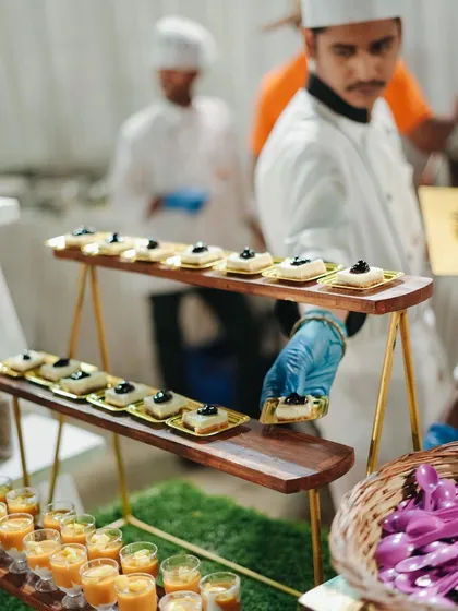 Our dessert spread is a feast for the eyes. Here, a chef arranges a variety of small, elegant desserts, ensuring a diverse and delightful selection for guests.