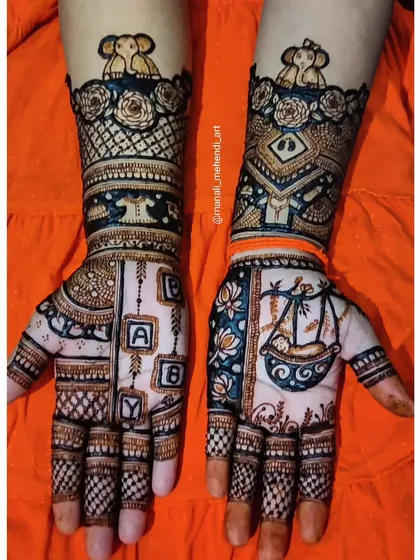 A creative baby shower mehandi with a baby in a cradle on one palm and 'BABY' spelled out in blocks on the other. The design is topped with cute elephant motifs.