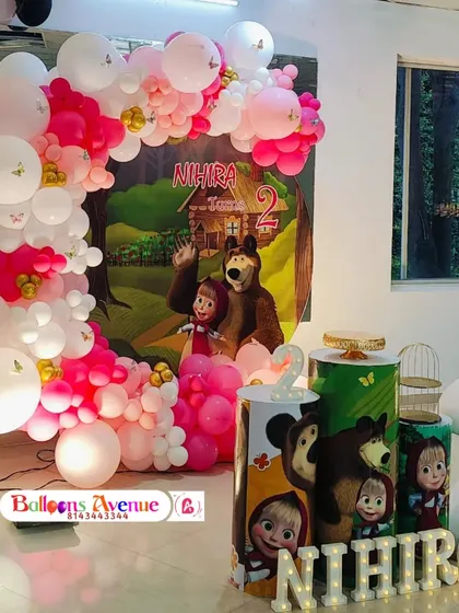 Another view of the Masha and the Bear party, highlighting the pink and white balloon arch and the light-up name and number props.