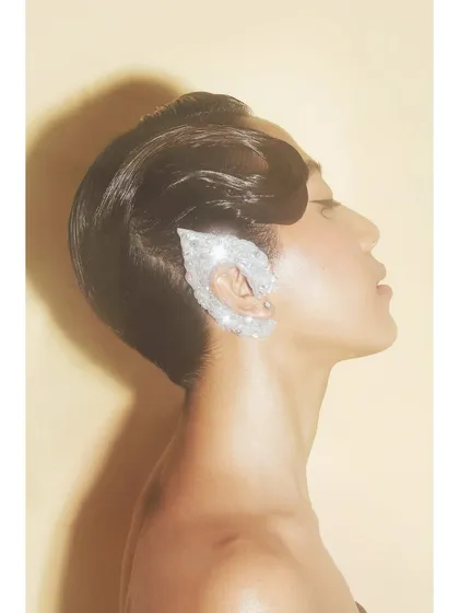 A profile shot from the 'Patricia' series focusing on a fantasy-inspired, sparkling ear cuff. The clean lighting and sculpted hair create a futuristic, elven look.