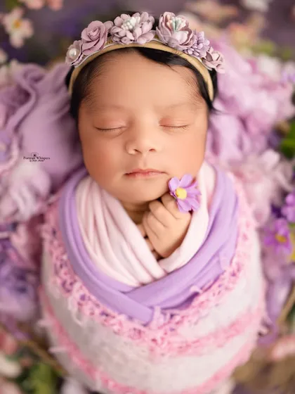 A close-up portrait focusing on the delicate features of a sleeping baby, crowned with a handmade floral headband. These macro-style shots are perfect for remembering just how tiny they were.