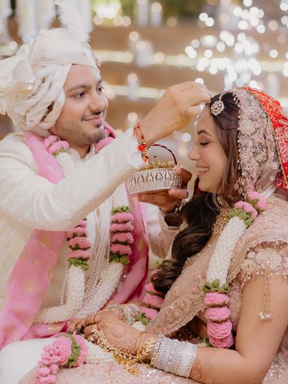 A precious moment from the wedding ceremony. The groom applies sindoor as the bride smiles, her glowing makeup looking flawless and radiant even in this intimate close up.
