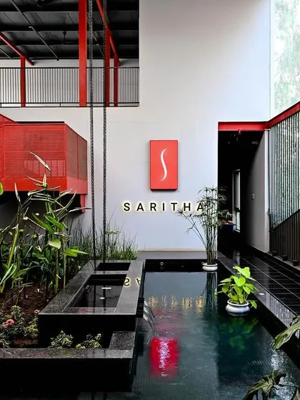 The integration of a multi-level water feature is central to our biophilic design for the SARITHA SERENE office. The sound and sight of water create a calming atmosphere, contrasting with the bold, industrial architecture.