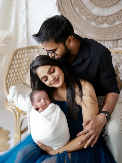 A father's gentle kiss on his partner's forehead as she holds their newborn. These are the heartfelt moments I strive to preserve for you.