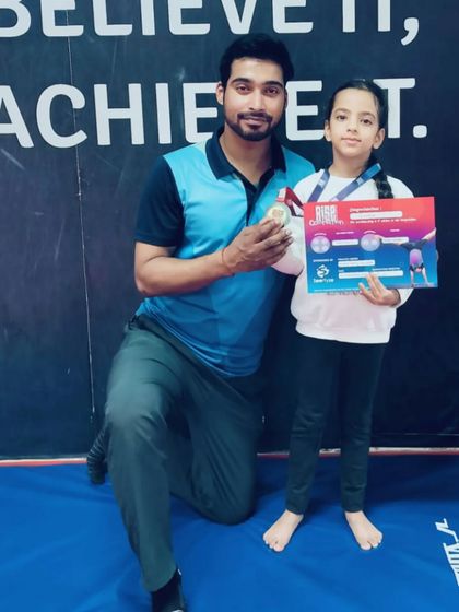 This gymnast holds her medal and certificate, showcasing her success in a recent competition.