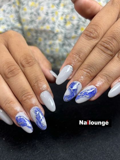 A cool and sophisticated grey set with accent nails featuring a blue and white marble or quartz effect.