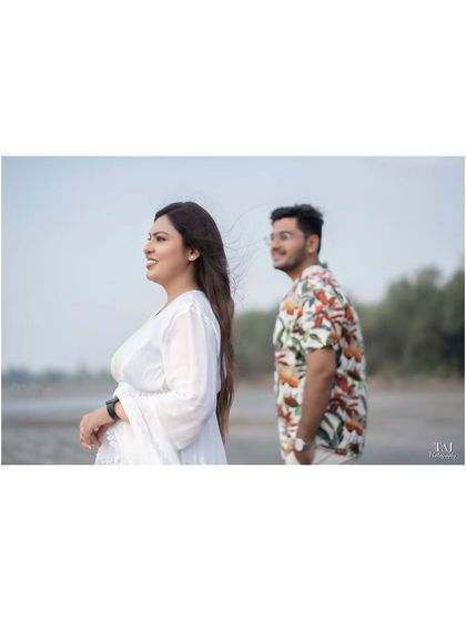 A candid shot of the bride looking out towards the sea, with the wind catching her hair. The groom is slightly out of focus in the background, creating a sense of story and depth.