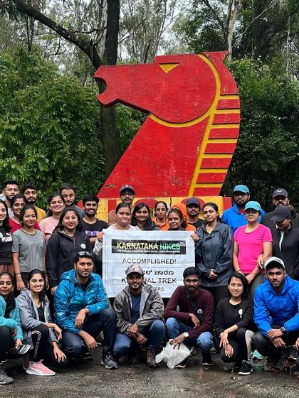 Our group posing with the banner in front of the iconic KIOCL horse-head statue, marking the start of the Kurinjal trek.