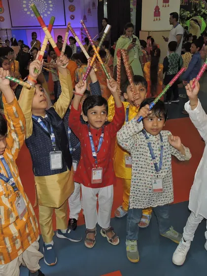 The energy is infectious as our young students, dressed in traditional attire, celebrate with a lively Dandiya dance, holding their sticks high.