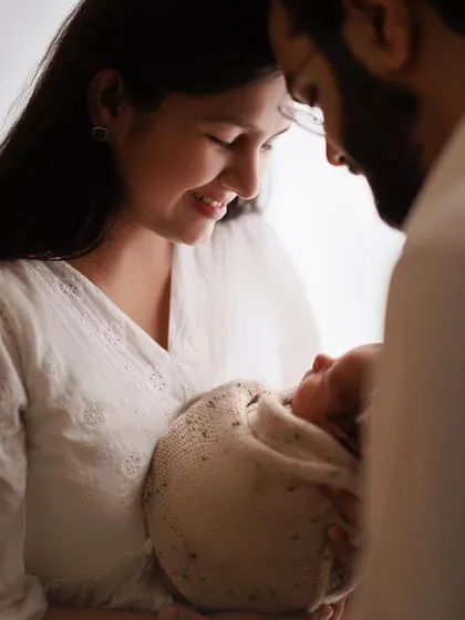 A mother gazing at her precious baby. This intimate, softly lit moment from a home session perfectly captures the beginning of their beautiful bond.