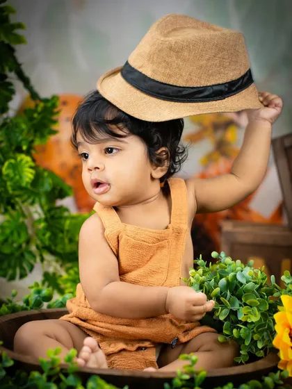 Tipping his hat in style. This playful shot from the jungle theme shows off the fun props and the adorable personality of this little adventurer.