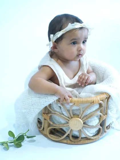 A classic newborn portrait featuring a baby nestled in a woven basket with a soft white blanket. This simple, clean setup is perfect for capturing the peaceful innocence of a newborn.