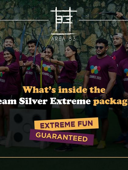 A corporate team in matching shirts poses with bows and arrows, ready for some extreme fun with Archery Tag.