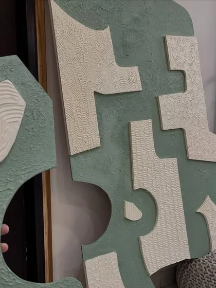 A close-up view of the custom-shaped textured panels. The contrast between the smooth green base and the raised white patterns adds a modern and graphic quality.