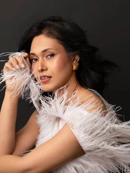 This portrait from a giveaway session is all about ethereal beauty. The white feathers add a soft, dreamlike quality, and her direct gaze is simply captivating.