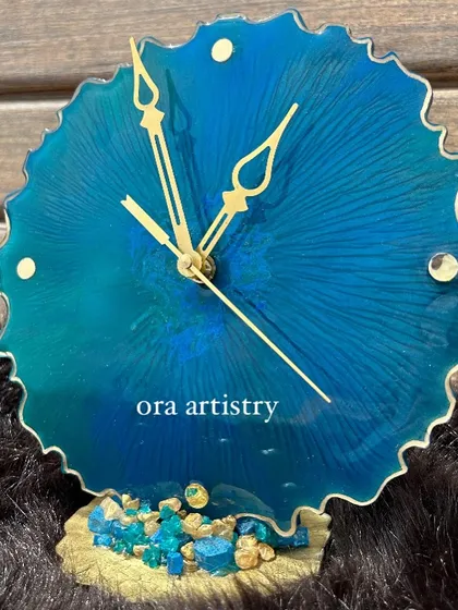 A mini ocean-themed clock with a scalloped edge and a base of blue crystals. It's a charming piece for any small space.