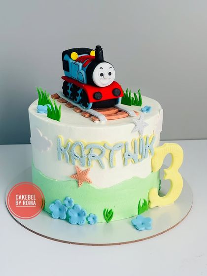 Choo choo! Here comes the Thomas the Tank Engine cake. I crafted a cheerful Thomas figure on edible tracks for Karthik's 3rd birthday, set against a simple, sweet landscape.