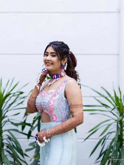A stylish bride posing for the camera, her mehandi adding a touch of tradition to her modern look.