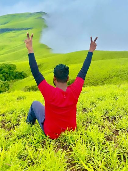 A trekker celebrating the view from the top of Nethravathi peak. The feeling of freedom and accomplishment is immense.