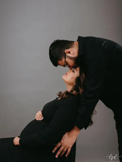 A tender kiss for the mom-to-be. This intimate black and white shot captures the love and anticipation, with her makeup looking soft and flawless.