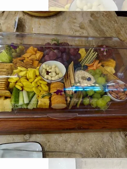 Our platters are designed for convenience and style. This cheese and cracker platter is presented under a clear acrylic cover, making it perfect for safe transport and outdoor events.
