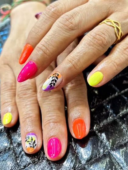 A pop of neon with a touch of nature. This design pairs bright, solid-colored nails with a hand-painted leaf art accent nail for a fun and tropical feel.