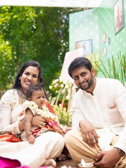 The family sits together on the floor for the traditional rituals of the naming ceremony, surrounded by beautiful decor.