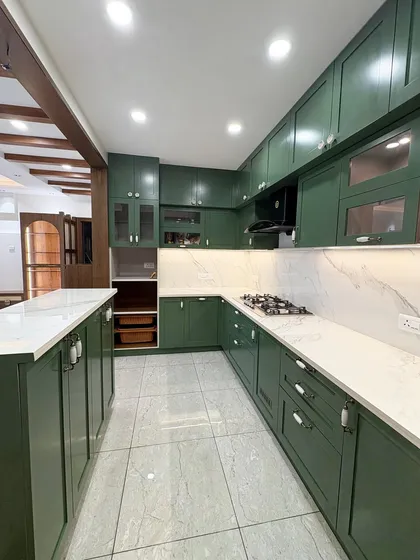 A wide shot of the green kitchen from image 47, revealing its spacious U-shape layout.
