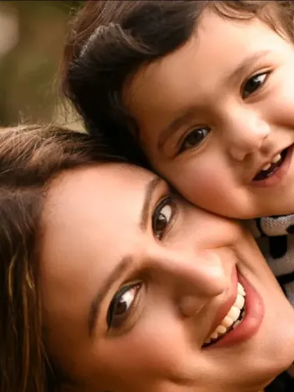 A sweet close-up of a mother and her son, cheek to cheek. The soft, natural lighting of the outdoors is incredibly flattering for portraits.
