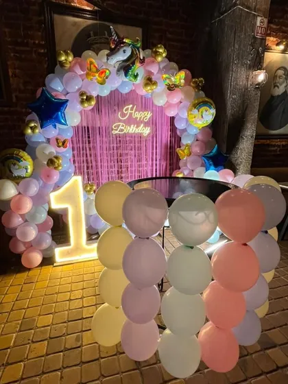 The unicorn birthday setup placed in a restaurant with rustic brick walls, showing how my decorations can fit into any venue.