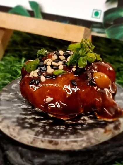 A single bite of glazed chicken with sesame seeds. This canapé is packed with umami flavour, perfect for a cocktail party.