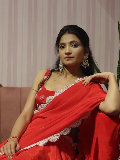 A model looking regal in our classic red saree with a scalloped lace border.