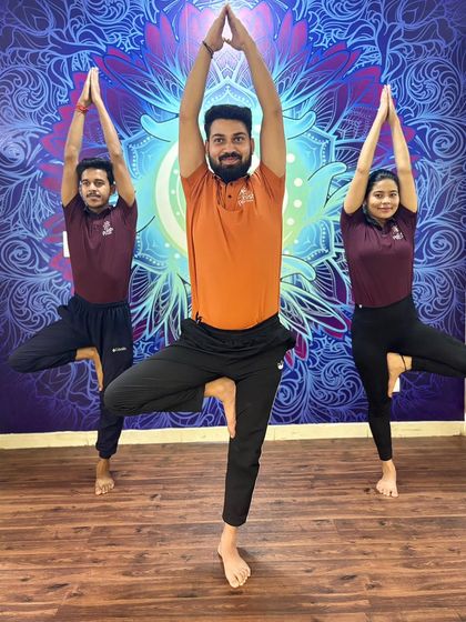 Instructors and students hold Tree Pose together, a practice that cultivates balance, focus, and a centered mind.