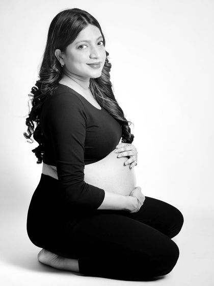 A simple, elegant black and white portrait of the mom-to-be kneeling. The bare bump is the focus, captured with soft, flattering light to create a timeless and tasteful image.