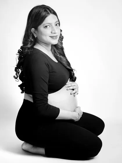 A simple, elegant black and white portrait of the mom-to-be kneeling. The bare bump is the focus, captured with soft, flattering light to create a timeless and tasteful image.