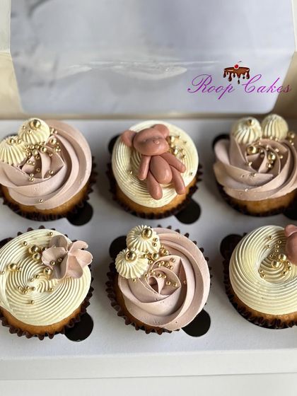 A box of teddy bear themed cupcakes, perfect for a baby's first celebration. I used a mix of delicate frosting swirls with golden sprinkles and handcrafted fondant teddy bears for a cute and classy look.