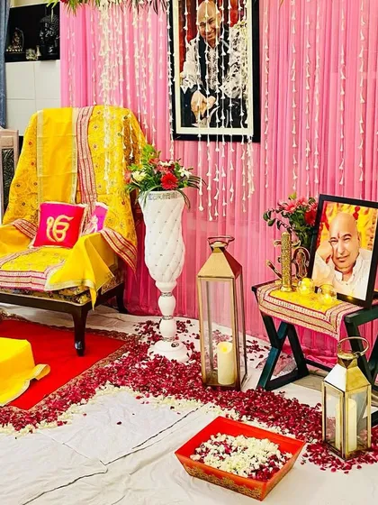 This angle shows the floor arrangement with scattered rose petals, lanterns with candles, and a tray of fresh flowers, all set up to create a peaceful environment for prayer.