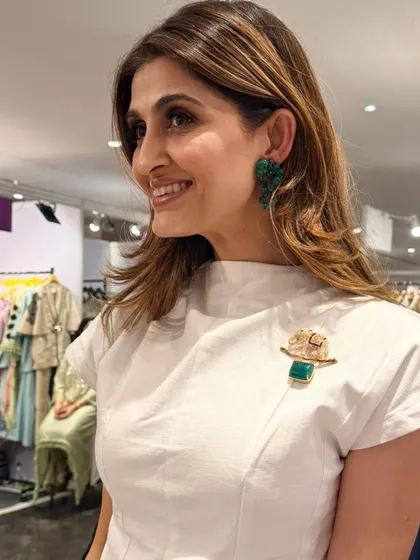 Another shot of our client looking radiant in our emerald cluster earrings and unique gold elephant brooch.